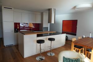 a kitchen with white cabinets and a wooden table at Exklusive Wohnung mit Panoramasicht auf Melchsee-Frutt in Frutt