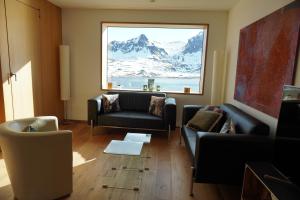 a living room with couches and a large window at Exklusive Wohnung mit Panoramasicht auf Melchsee-Frutt in Frutt