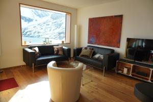 a living room with two couches and a television at Exklusive Wohnung mit Panoramasicht auf Melchsee-Frutt in Frutt