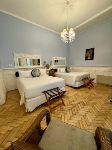 a bedroom with two beds and a chandelier at Villa Vicuña Salta Hotel Boutique in Salta +116 photos