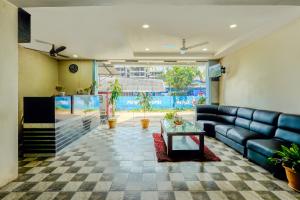 a living room with a couch and a large aquarium at Hotel Ocean View, Rushikonda Beach in Visakhapatnam