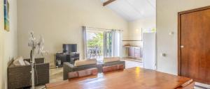 een woonkamer met een tafel en een keuken bij Wayaca Mini Resort in Willemstad