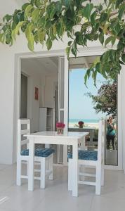 萨尔雷Villa Cristina Alojamento, Praia de Chaves, Boa Vista, Cape Verde, WI-FI的白色的桌椅,享有海景