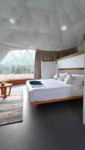 Un dormitorio con una cama grande y una ventana grande. en Highland Glamping Luxury Dome tent, en Paro