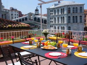 a table with food and drinks on a balcony at Ca Dadda terrace at Rialto Bridge -historic residence equipped with all comforts in Venice