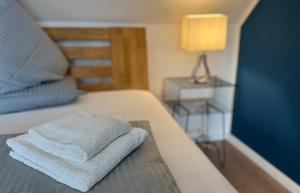 a stack of towels sitting on top of a bed at MEINpartments - Full service living Apartmenthouse in Wolfsburg