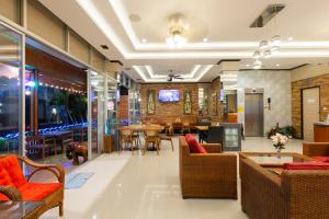 Un vestíbulo con mesas y sillas y un comedor. en Baan KetKaew Patong, en Patong Beach