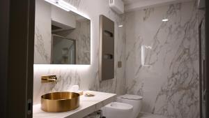 a bathroom with a gold sink and a toilet at Hotel Wellness Magione Papale in LʼAquila +5 photos