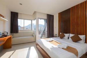 una habitación de hotel con dos camas y un sofá en Baan KetKaew Patong, en Patong Beach