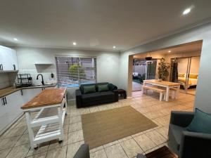 a living room with a couch and a table at AquaPalms Hideaway - Family Friendly Pool - Hot Tub - Indoor Braai in Cape Town