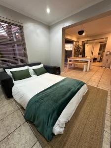 a bedroom with a large bed and a table at AquaPalms Hideaway - Family Friendly Pool - Hot Tub - Indoor Braai in Cape Town +36 photos