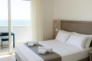 ein Schlafzimmer mit einem großen weißen Bett mit zwei Kissen in der Unterkunft Residence Hotel Piccadilly in Rimini