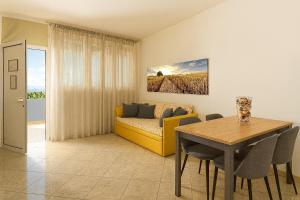 ein Wohnzimmer mit einem gelben Sofa und einem Tisch in der Unterkunft Residence Hotel Piccadilly in Rimini