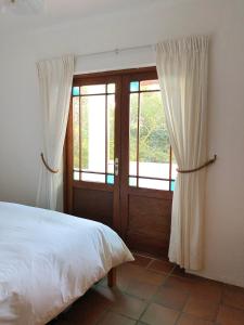 a bedroom with a bed and a sliding glass door at Eensgevonden Vineyard Cottages in Rawsonville +14 photos