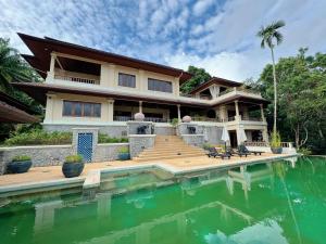 a house with a swimming pool in front of it at 普吉高端康养泳池别墅 in Layan Beach