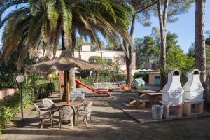 a park with tables and chairs and a playground with a slide at Lido I Palmizi in Capoliveri