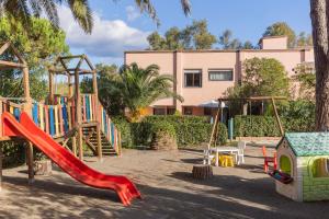 a playground in front of a building with a slide at Lido I Palmizi in Capoliveri