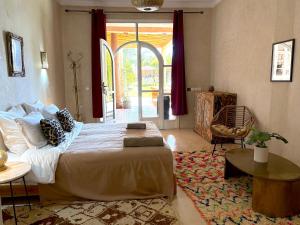 ein Schlafzimmer mit einem Bett und einer Tür zu einer Terrasse in der Unterkunft Palais Bohemia in El Rhechat + 67 Fotos