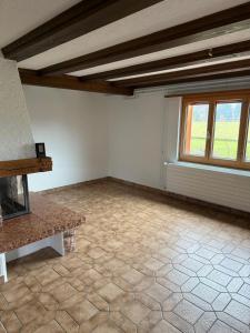 LaVida Peak Mountain Retreat in Frutigen في Wengi bei Frutigen: غرفة معيشة فارغة بها موقد ونوافذ