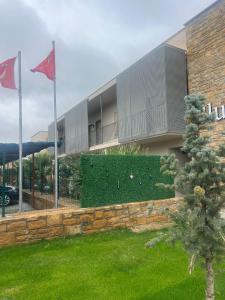 GökçeadaにあるBlue Inn Hotelの庭の前に緑の生垣がある建物
