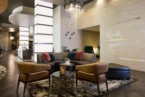 Un vestíbulo con un sofá y sillas y una mesa. en Archer Hotel Falls Church, en Fairfax