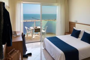 ein Hotelzimmer mit Bett und Blick aufs Meer in der Unterkunft Residence Hotel Piccadilly in Rimini