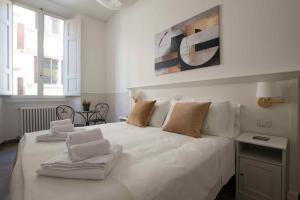a bedroom with a white bed with two towels on it at Hotel Canada in Florence