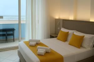 a bedroom with a large bed with yellow pillows at Residence Hotel Piccadilly in Rimini