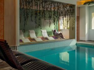 ein Swimmingpool mit Liegestühlen und ein Swimmingpool in der Unterkunft Novotel Bucharest City Centre in Bukarest
