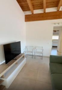 un soggiorno con TV e 2 sedie di Bed&BikeRome PAOLUCCI a Cesano