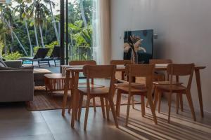 een eetkamer met een houten tafel en stoelen bij Chic Koh Phangan Villa with Pool Bliss in Ko Phangan