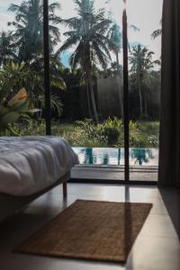 een slaapkamer met een bed en uitzicht op een zwembad bij Chic Koh Phangan Villa with Pool Bliss in Ko Phangan