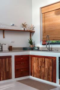 een keuken met houten kasten en een spoelbak bij Chic Koh Phangan Villa with Pool Bliss in Ko Phangan