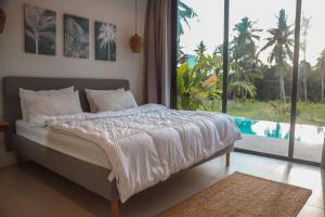 een bed in een slaapkamer met een groot raam bij Chic Koh Phangan Villa with Pool Bliss in Ko Phangan +42 foto's