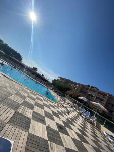 a large swimming pool with chairs and a sunvisor at L'Eden - T2 climatisé piscine renové in Balaruc-les-Bains