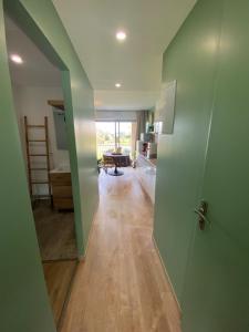 a room with a hallway with green walls and a kitchen at L'Eden - T2 climatisé piscine renové in Balaruc-les-Bains