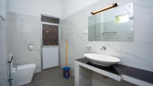 ein weißes Badezimmer mit Waschbecken und Toilette in der Unterkunft Shady mango villa in Sigiriya + 65 Fotos