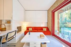 a living room with a red couch and a table at Casa Mora in Cerro Lago Maggiore