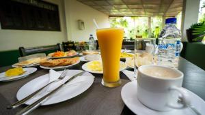 einen Tisch mit Tellern und einer Tasse Kaffee in der Unterkunft Shady mango villa in Sigiriya