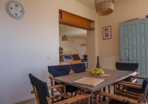 une table à manger avec des chaises et une horloge murale dans l'établissement Aegean Bliss - Marathos Retreat Samos, à Marathokampos 20 autres photos