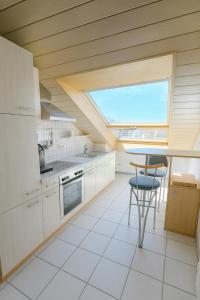 a kitchen with white cabinets and a skylight at Außergewöhnliche 5 Zimmer Penthouse Wohnung in Kehl in Kehl am Rhein