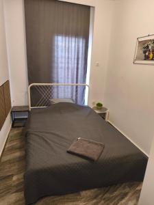 Posto letto in una piccola camera con finestra di Michaniona apartment a Néa Michanióna