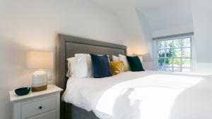 a bedroom with a large white bed and a window at Rutherglen in Beaumaris