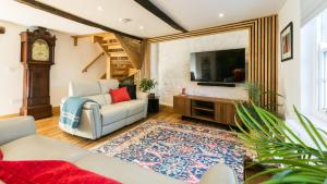 a living room with a couch and a tv and a clock at Rutherglen in Beaumaris