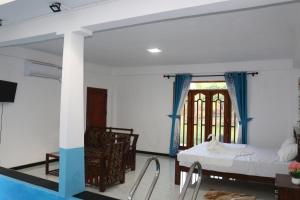 una camera con un letto, un tavolo e una finestra di Wadula Resort a Nochchiyagama