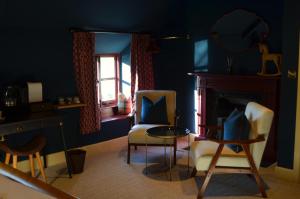a blue room with chairs and a table and a fireplace at The Hollow Bottom in Guiting Power