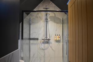 um banheiro com chuveiro e paredes de mármore branco em The Hollow Bottom em Guiting Power mais 76 fotografias