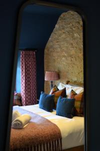 um quarto com uma cama grande com uma parede de pedra em The Hollow Bottom em Guiting Power