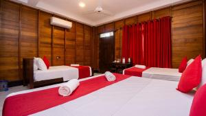 ein Schlafzimmer mit zwei Betten und einem roten Vorhang in der Unterkunft Shady mango villa in Sigiriya
