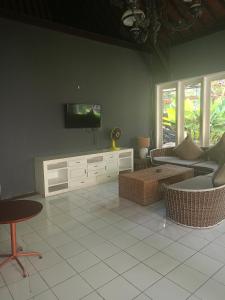 a living room with a flat screen tv on a wall at Casavina residen kubu manyar 202 in Dalung